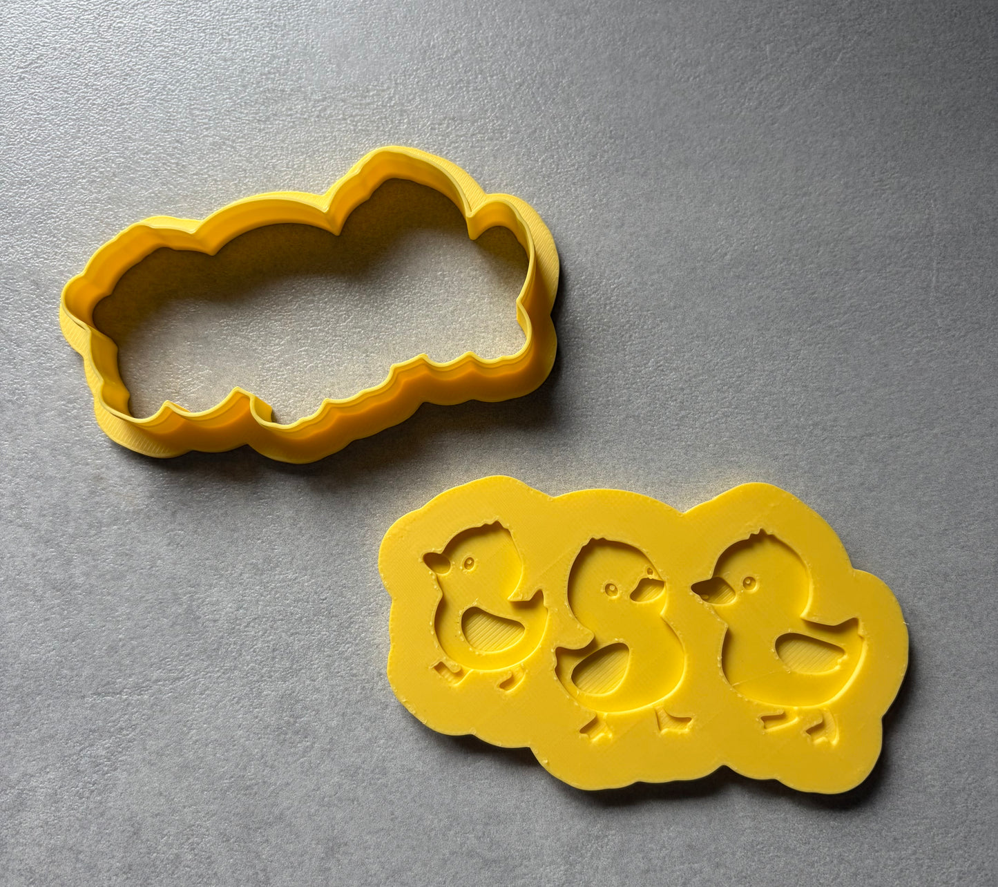 Three little ducks Yellow cookie cutters on a gray surface