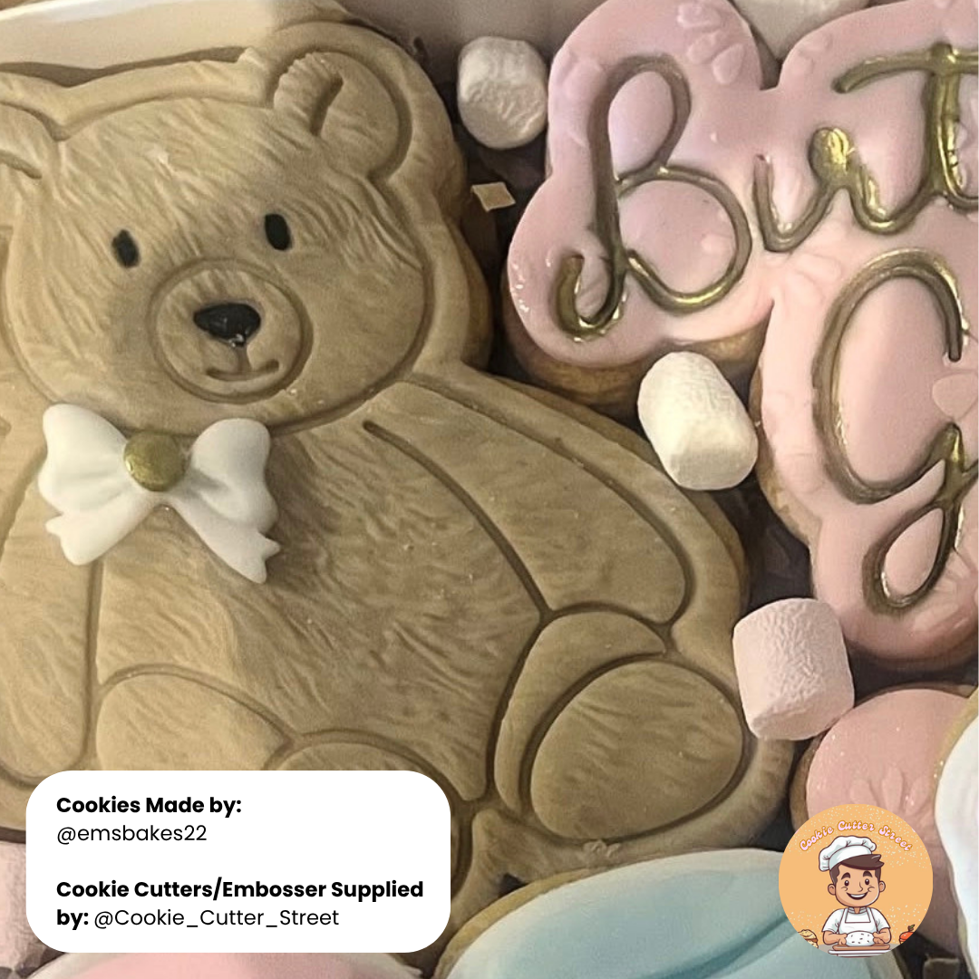 Cookies shaped like a teddy bear and with decorative letters, made by emsbakes22.