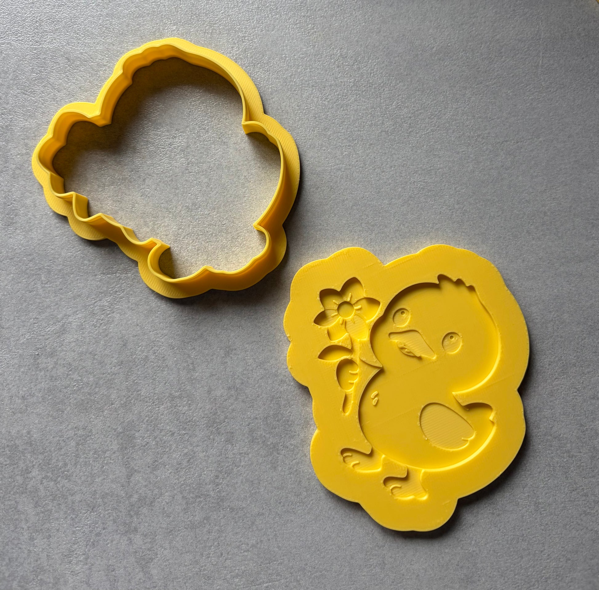 Duck with flower yellow cookie cutter on a grey background