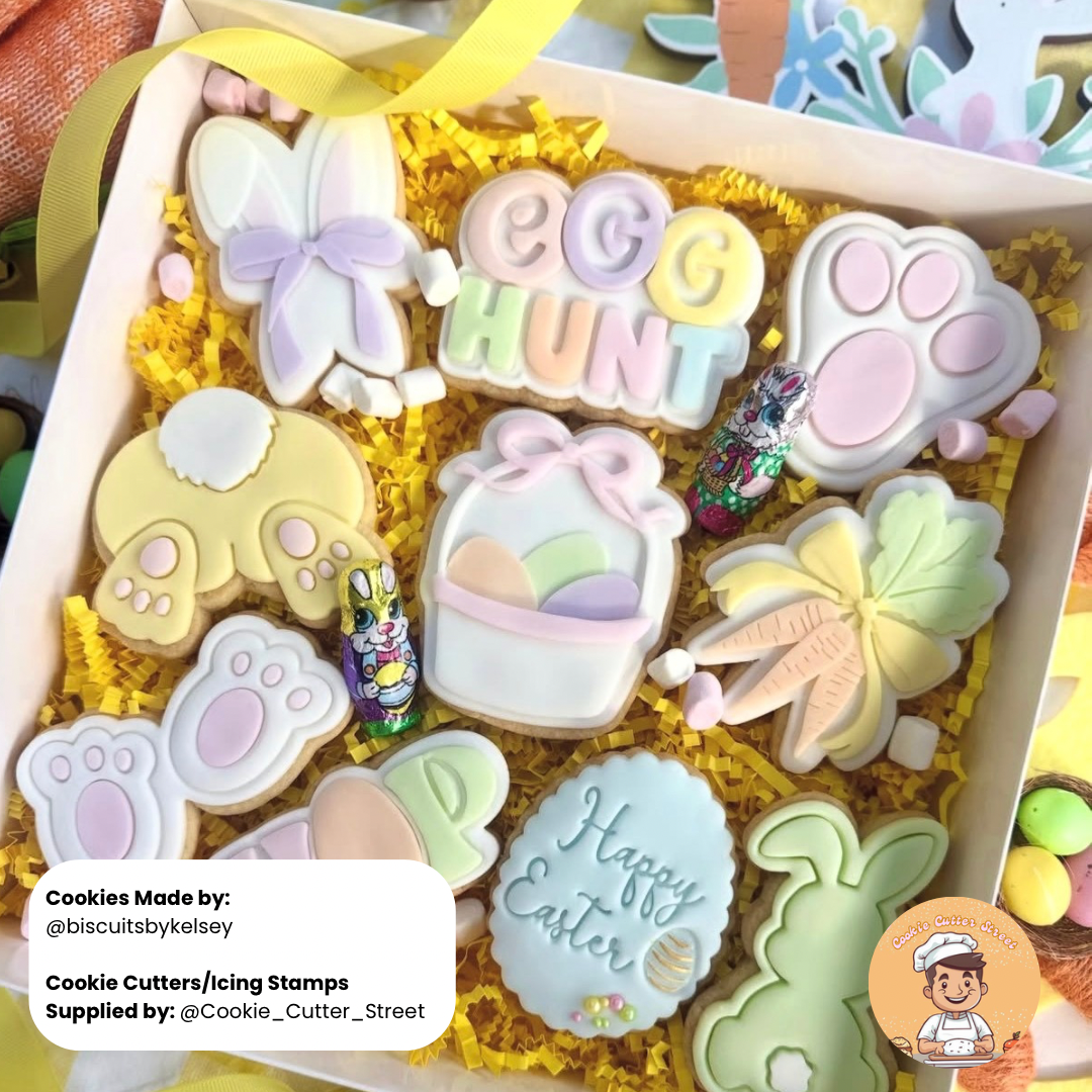 Decorative Easter-themed cookies in a box with cookie cutters and stamps.