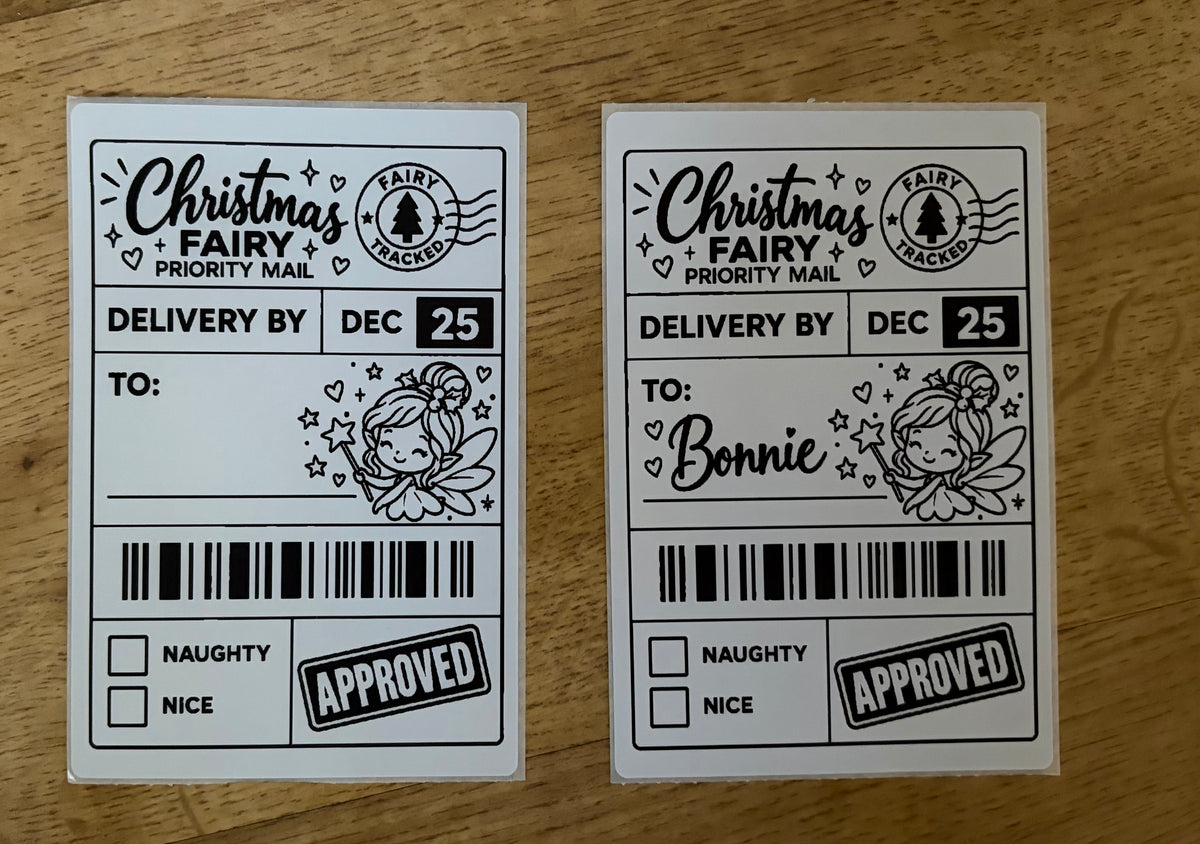 Two novelty Christmas Fairy Priority Mail stamps shown side by side on a wooden surface. The left stamp is blank, and the right stamp shows 'TO: Bonnie' filled in.