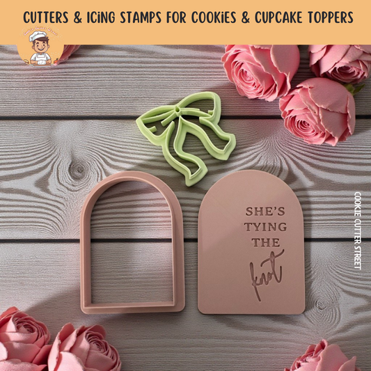She's Tying the Knot Bride To Be Cookie cutters and stamp with floral decorations on a wooden surface