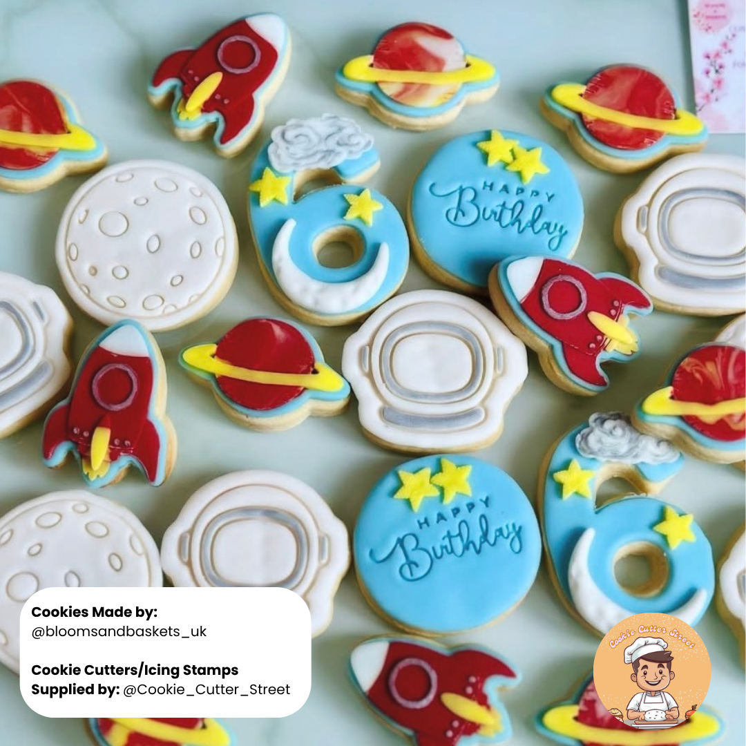 Space-themed birthday cookies with rockets, planets, and moons on a light green background.