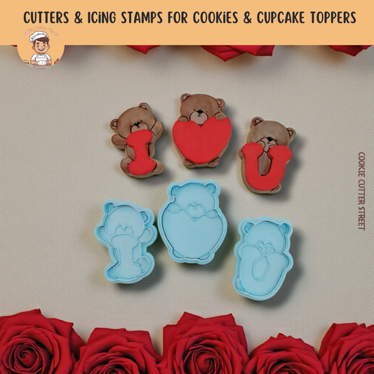 Cookie cutters and icing stamps shaped like teddy bears and hearts with roses on a neutral background.