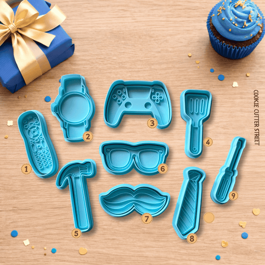 Dad-themed cookie cutter collection featuring gaming controller, remote control, watch, tie, tools, sunglasses and moustache designs for Father’s Day and birthday cookies.
